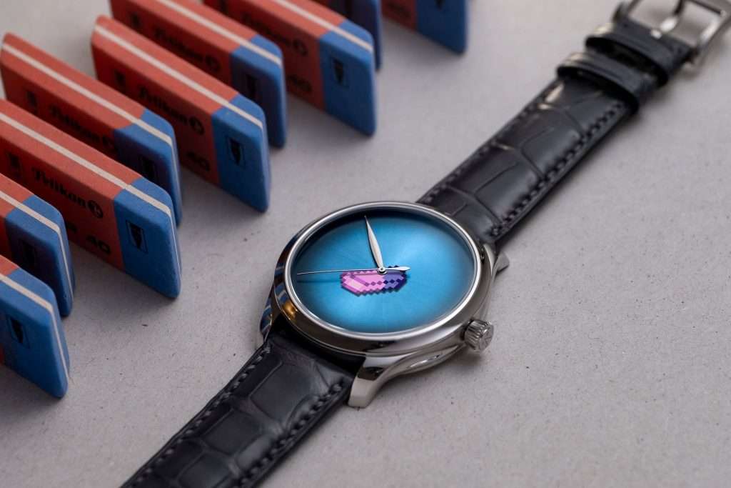 H. Moser × seconde seconde Endeavour Concept watch featuring a pixelated eraser hour hand, photographed beside Pelikan erasers.