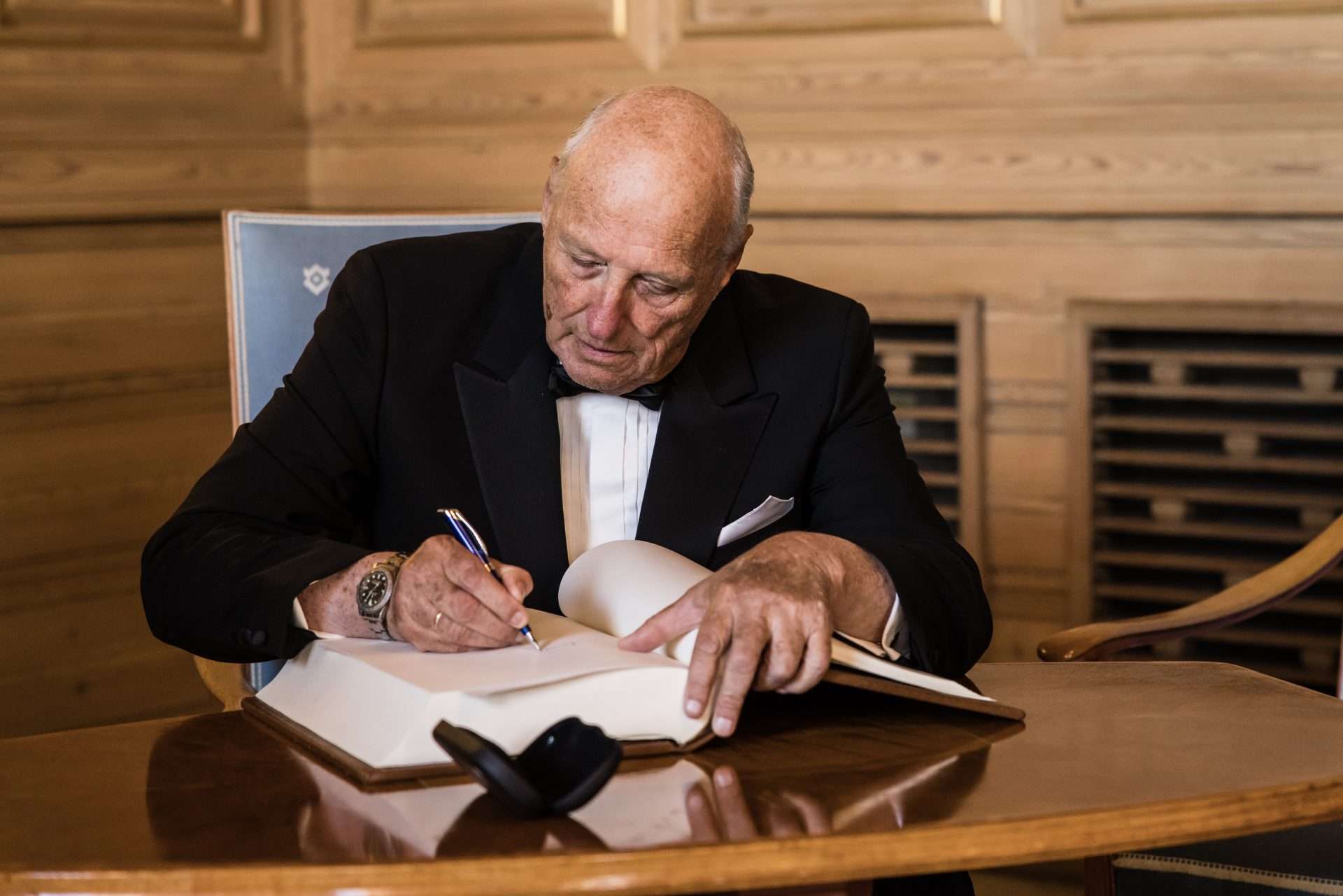 King Harald’s Rolex GMT-Master visible on his right wrist as he signs a protocol at Oslo City Hall in 2022